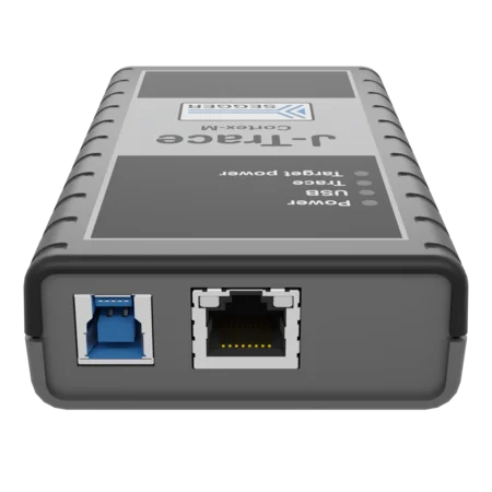 A gray electronic device with a rectangular shape. It has one USB port and one Ethernet port on the left side. The top features a label with the text "1-Trac" and "Cortech-M," alongside indicator lights for power and usage.