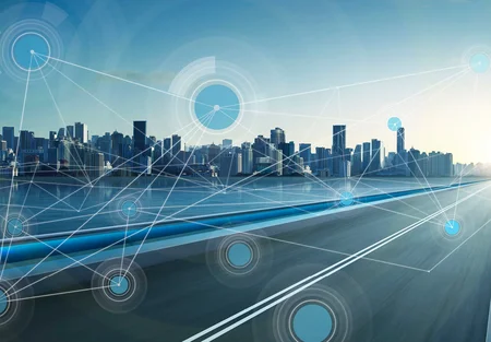 A futuristic city skyline is visible against a blue sky, with abstract technological lines and circles representing connectivity and data flow. A road runs along the waterfront, illustrating the concept of smart urban infrastructure.