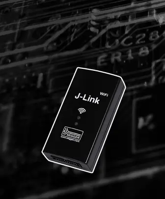 Image of a small, rectangular black device labeled "J-Link WiFi" with indicator lights on the front. The device is positioned against a blurred background of circuit patterns, suggesting a technological or electronic context.