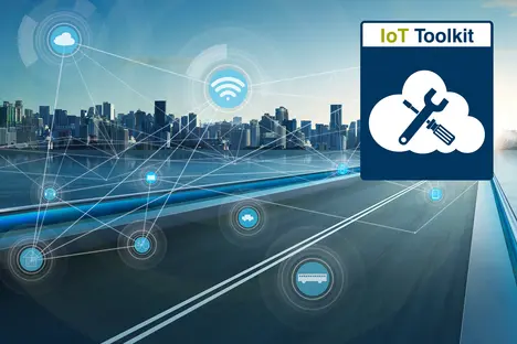 An urban skyline with buildings and water is shown in the background, featuring a technology concept. The foreground has a road with icons representing various Internet of Things (IoT) devices and a cloud symbol with a wrench, suggesting tools for IoT development.