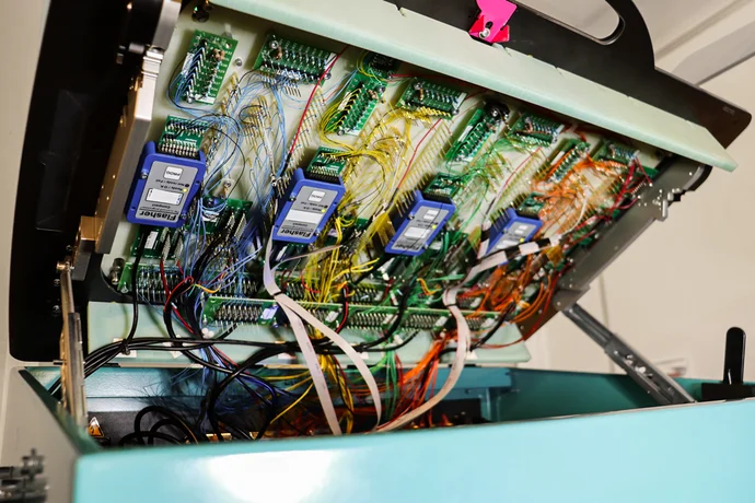 The image shows an opened electronic device with multiple circuit boards and colorful wiring. Several blue modules labeled "Fierce" are visible, attached to the circuit boards. The interior design highlights the complexity of the internal components and connections within the device.