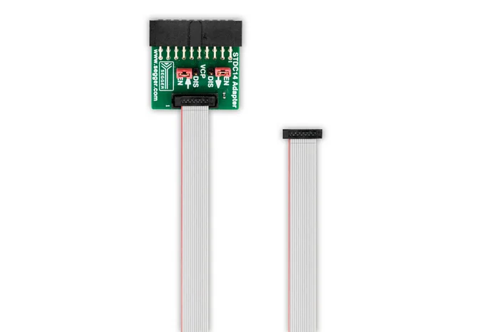 Image shows a STDC14 Adapter with a green circuit board featuring connection points and labels for "EN," "DIS," and "V0." A flexible ribbon cable is connected to the adapter, with the other end exposed and unconnected. The background is plain white.