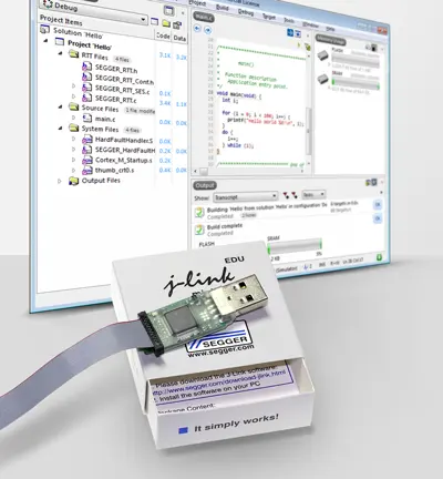 The image features a J-Link EDU debugging tool placed on an open box, with a ribbon cable attached. In the background, a computer screen displays a programming interface with code and project files visible, illustrating a debugging environment for software development.