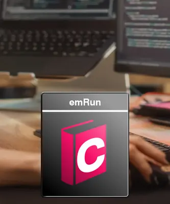 An image featuring the logo for "emRun," displayed prominently, with a stylized book icon in pink and white. In the background, a hand is seen on a keyboard, and computer screens with code are visible, suggesting an environment focused on technology and programming.