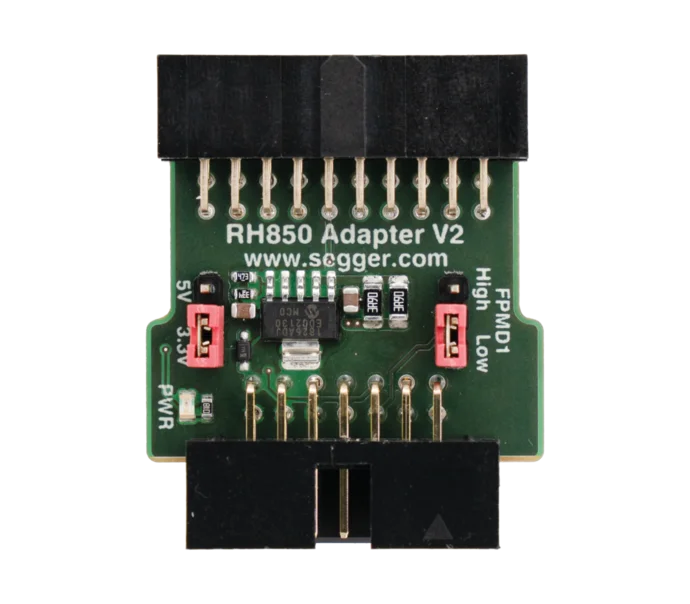 A green circuit board labeled "RH850 Adapter V2" featuring a central chip, several pins for connections, a red switch, and markings for power and signal settings. The design includes a connector at the bottom for interfacing with other devices.